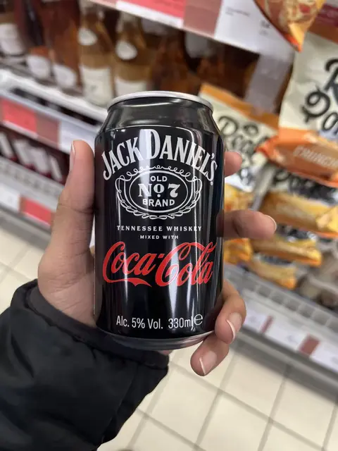 A guy holding a can of Jack Daniels Cola in lower resolution